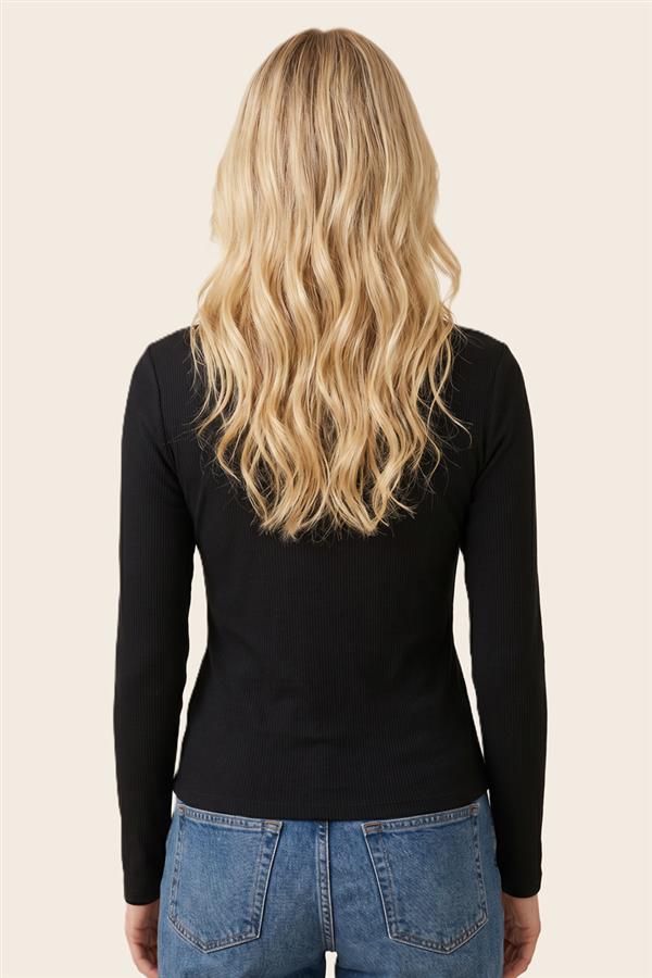 A woman viewed from the back wearing a fitted black long-sleeve top and blue jeans against a plain light beige background.