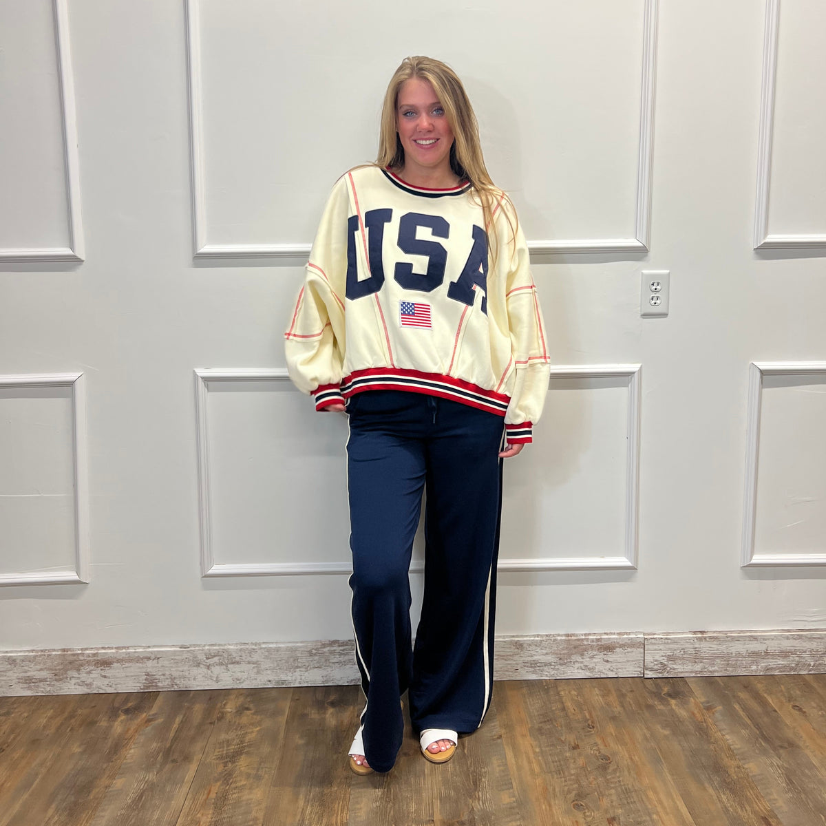 Person wearing a vintage-style jacket with 'USA' text in front of a white door.