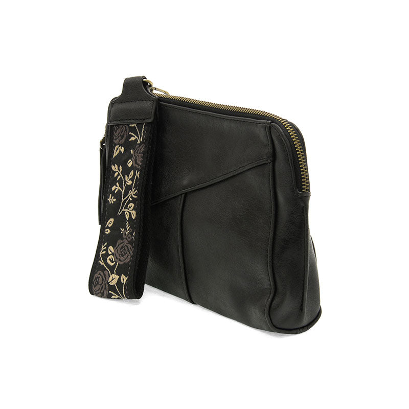 Black leather crossbody bag with floral strap on a white background