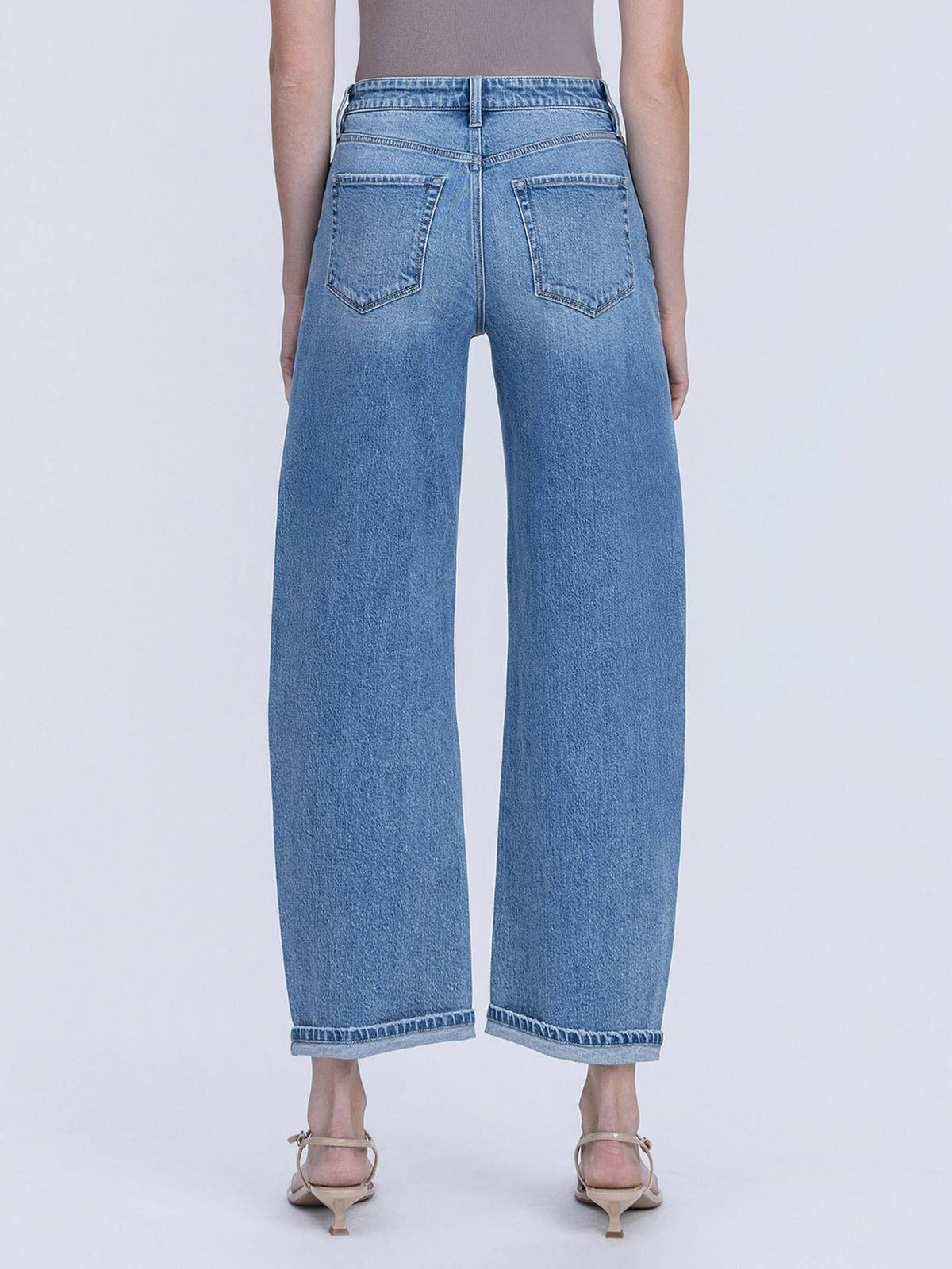 Person wearing light blue jeans on a white background