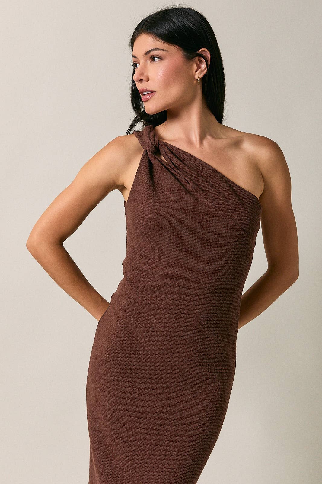 Model wearing Apricot Lane Duluth brown one-shoulder midi dress with a textured knit fabric and cutout detail.