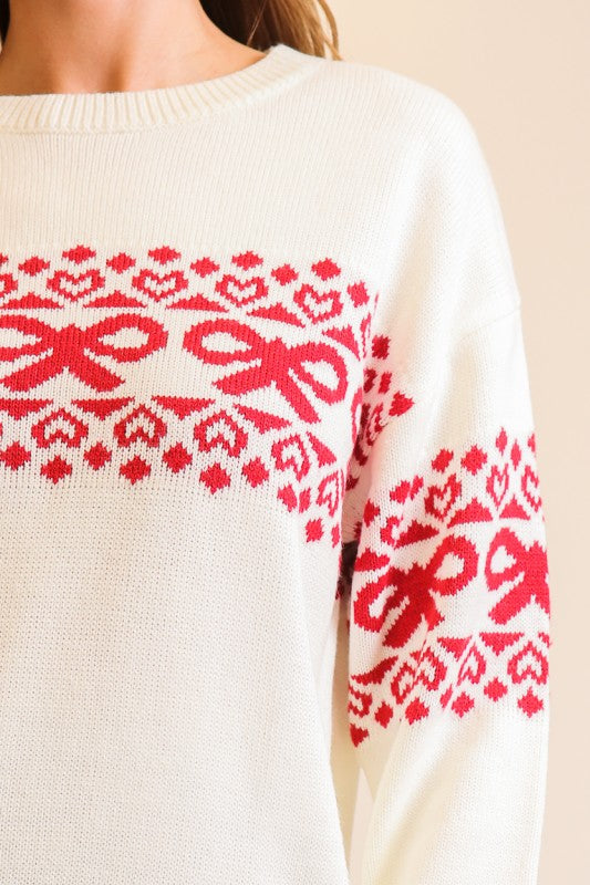 Apricot Lane Duluth Noelle sweater in cream with red Fair Isle pattern featuring festive bow and heart motifs.