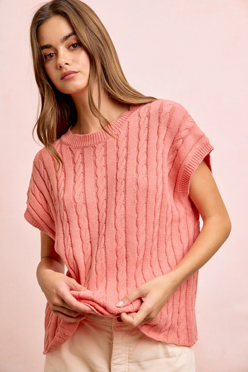 Woman wearing a pink knitted top against a pink background