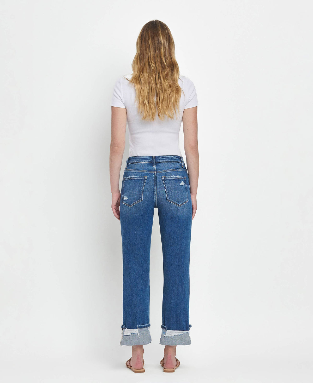 Person wearing blue jeans and a white t-shirt on a white background