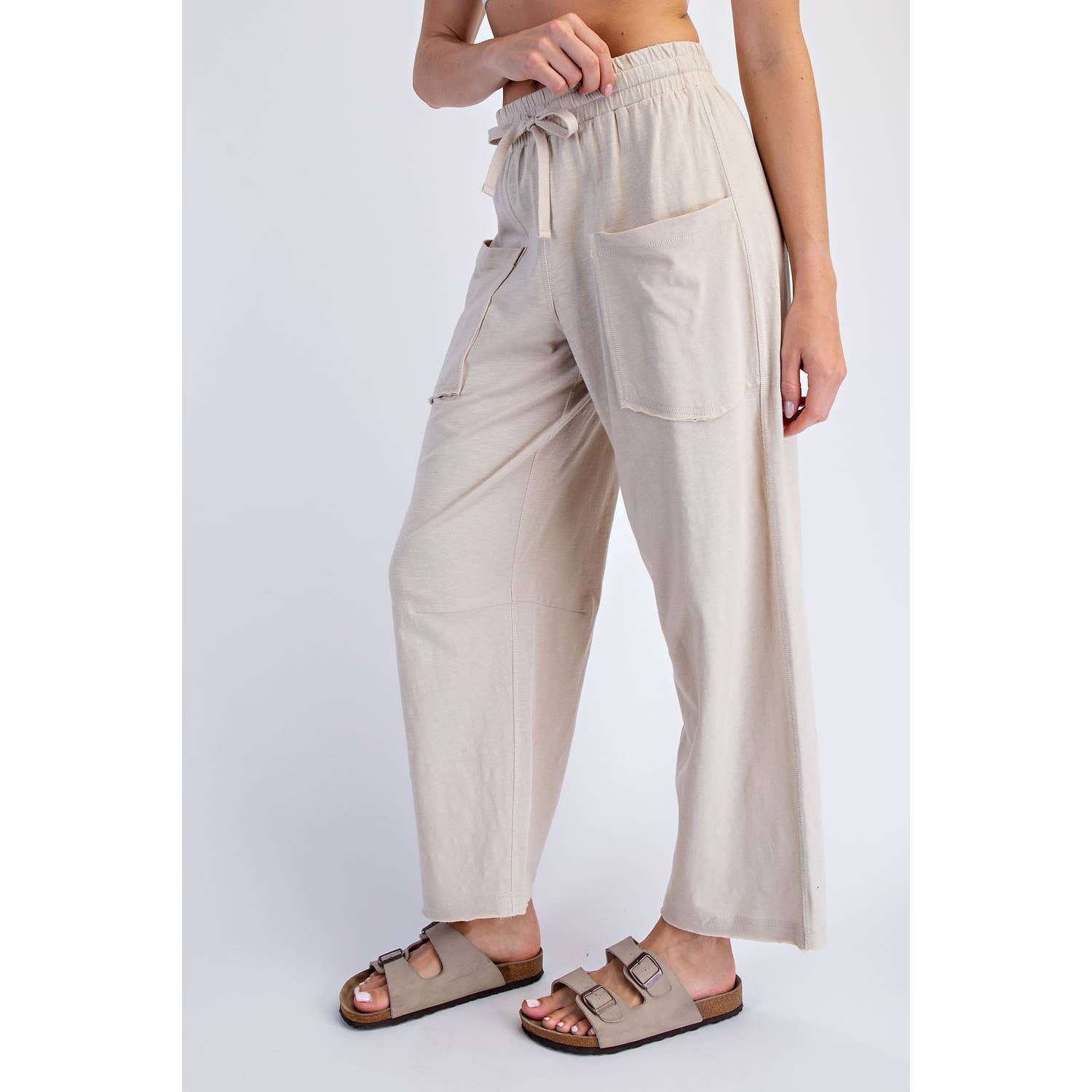 Beige pants worn by a person on a white background