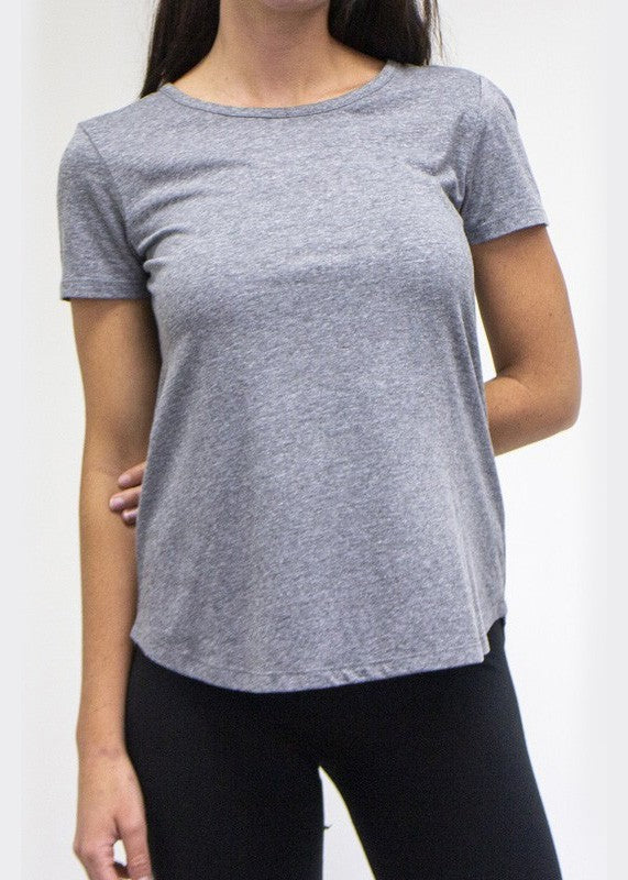 Person wearing a gray t-shirt and black leggings on a white background
