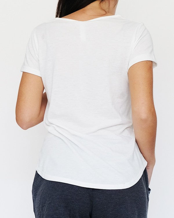 Person wearing a plain white t-shirt on a light gray background