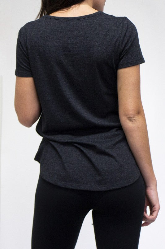 Person wearing a dark gray t-shirt and black pants on a white background