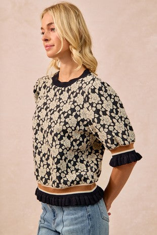 Woman wearing a floral-patterned sweater with a plain background