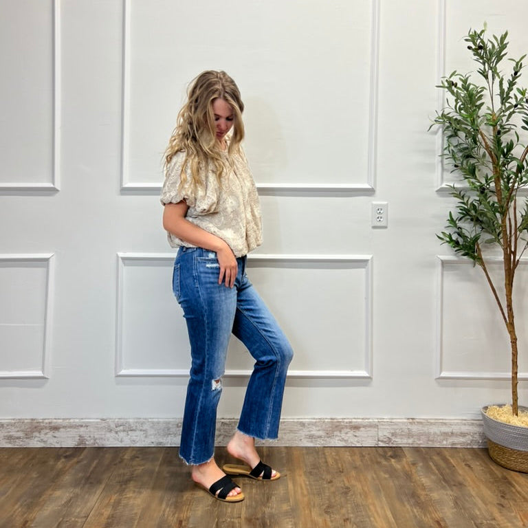 Woman standing in a room with white paneled walls and a plant.
