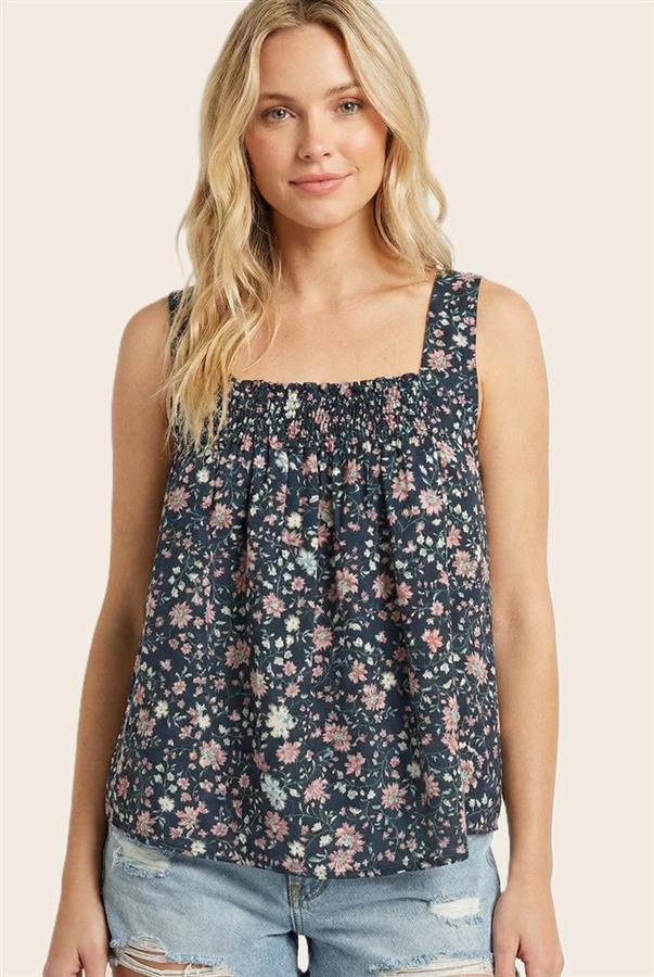Woman wearing a floral sleeveless top against a beige background