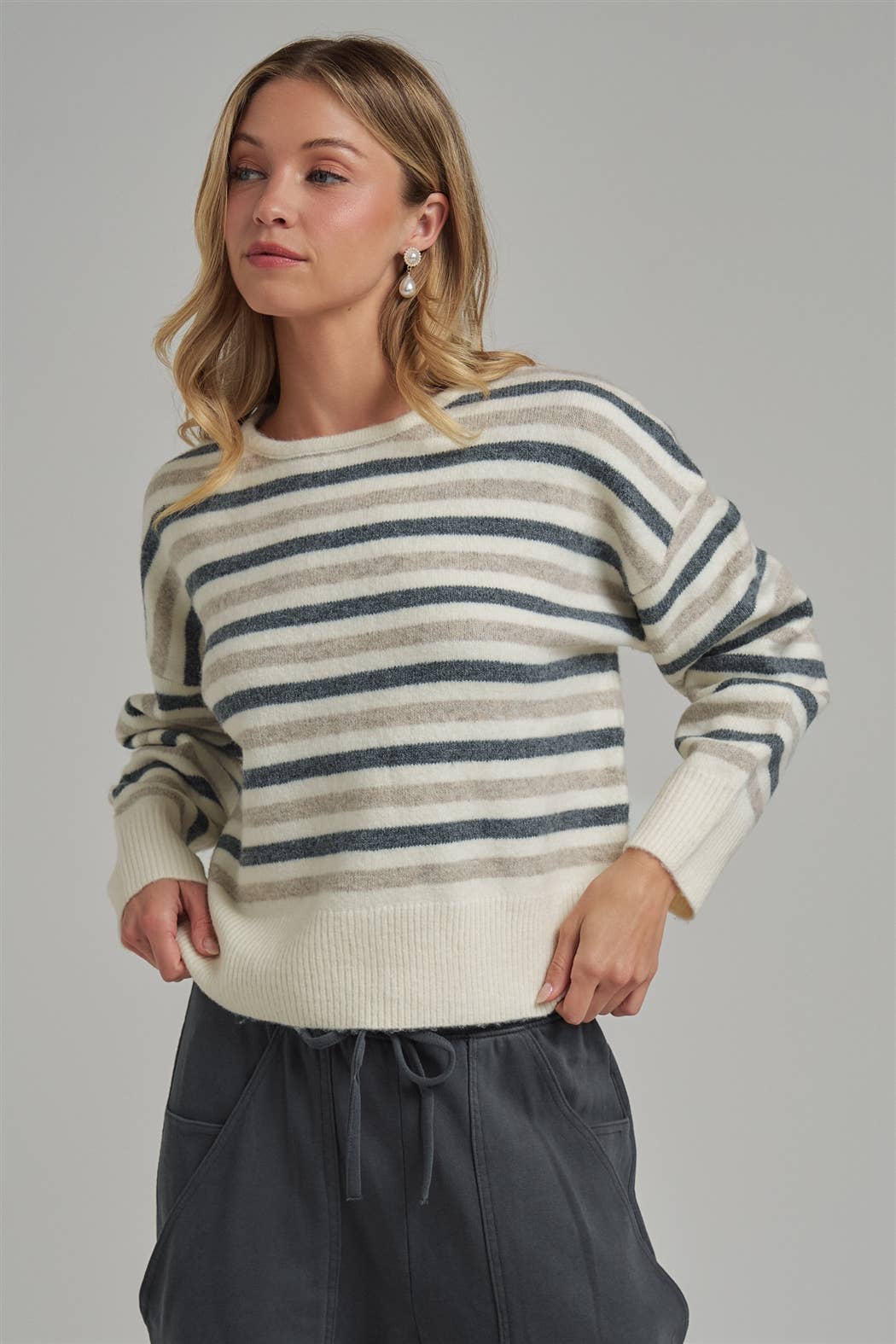 Woman wearing a striped sweater against a gray background
