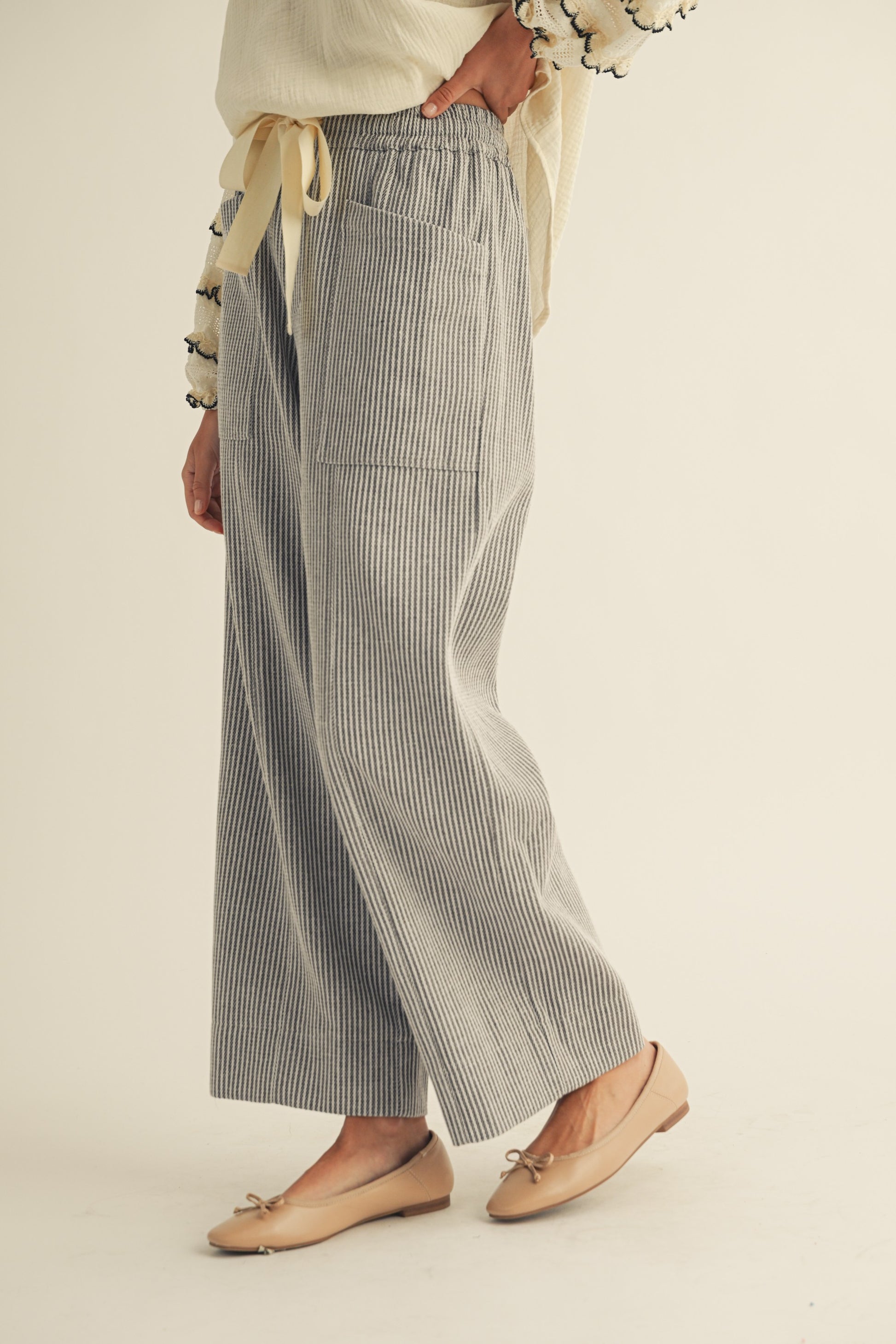 Person wearing gray checkered pants on a beige background