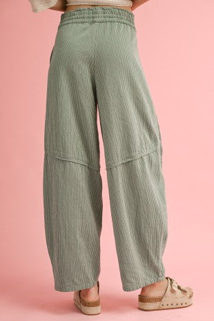 Green checkered pants worn by a person on a pink background