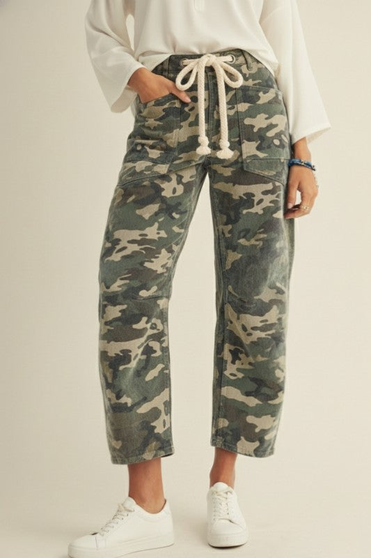 Person wearing camouflage pants with a white background