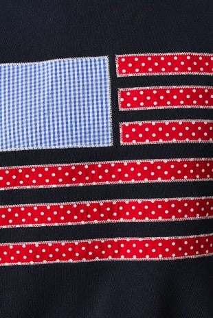 Close-up of a fabric with an American flag pattern featuring red, white, and blue colors.
