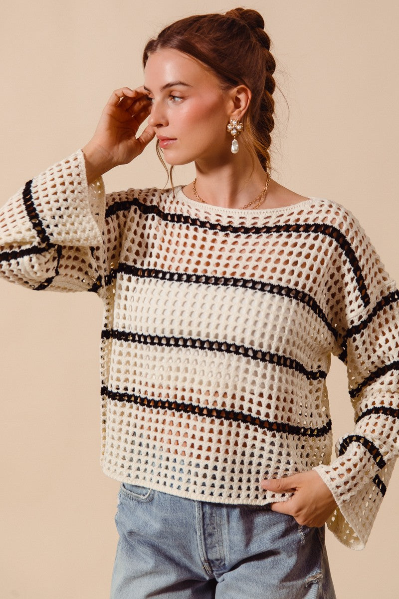 Woman wearing a black and white patterned sweater against a beige background