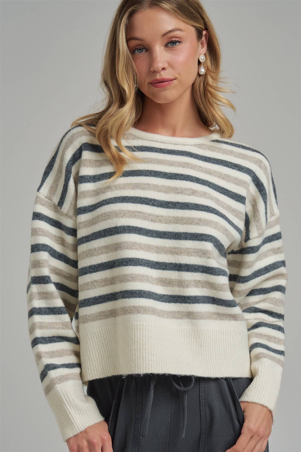 Woman wearing a striped sweater against a gray background