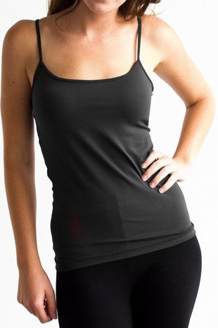Woman wearing a black tank top and leggings on a white background