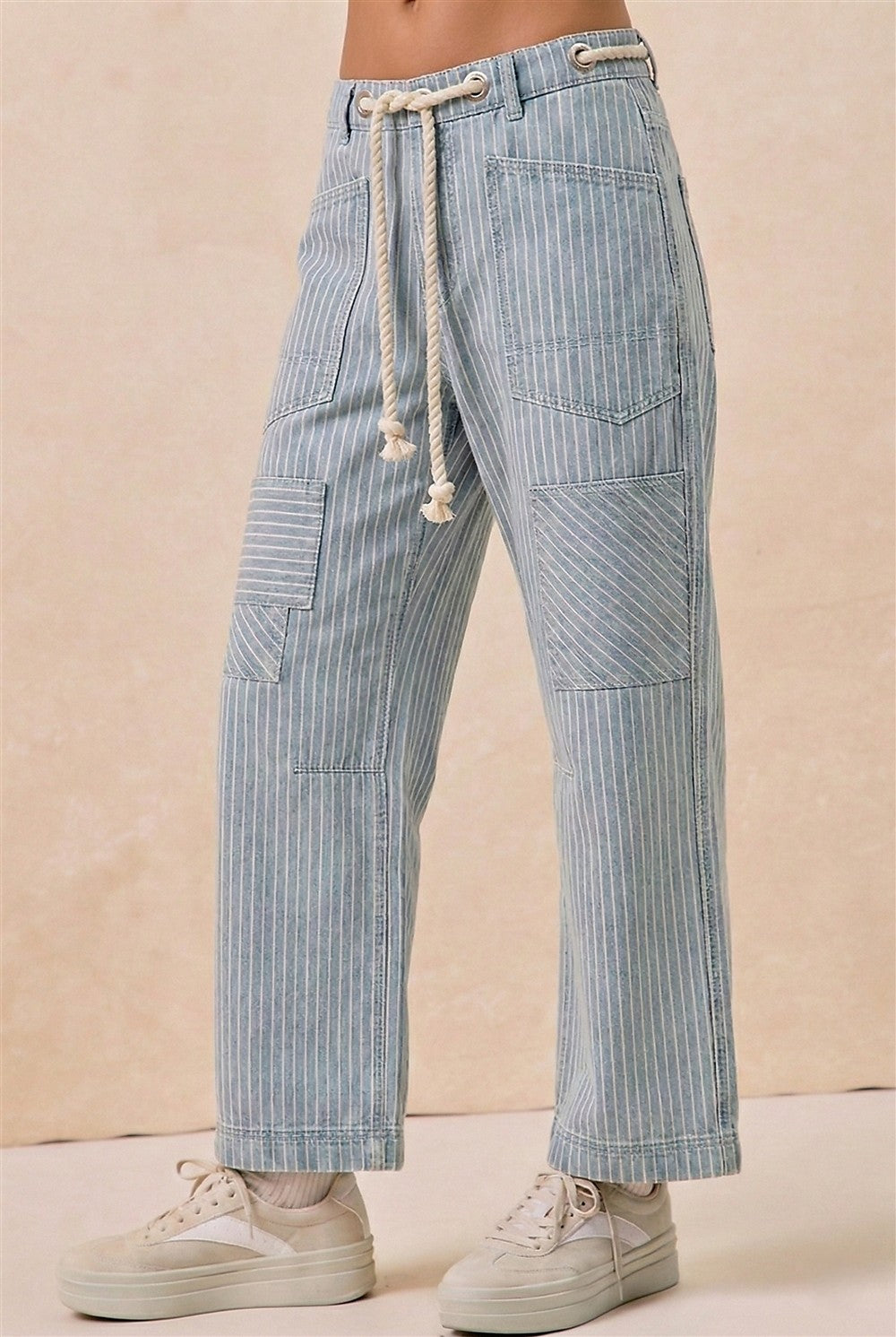 Light blue striped pants with drawstring waist on a beige background