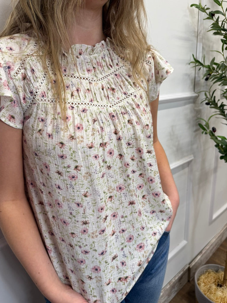 Person wearing a floral blouse with a white background
