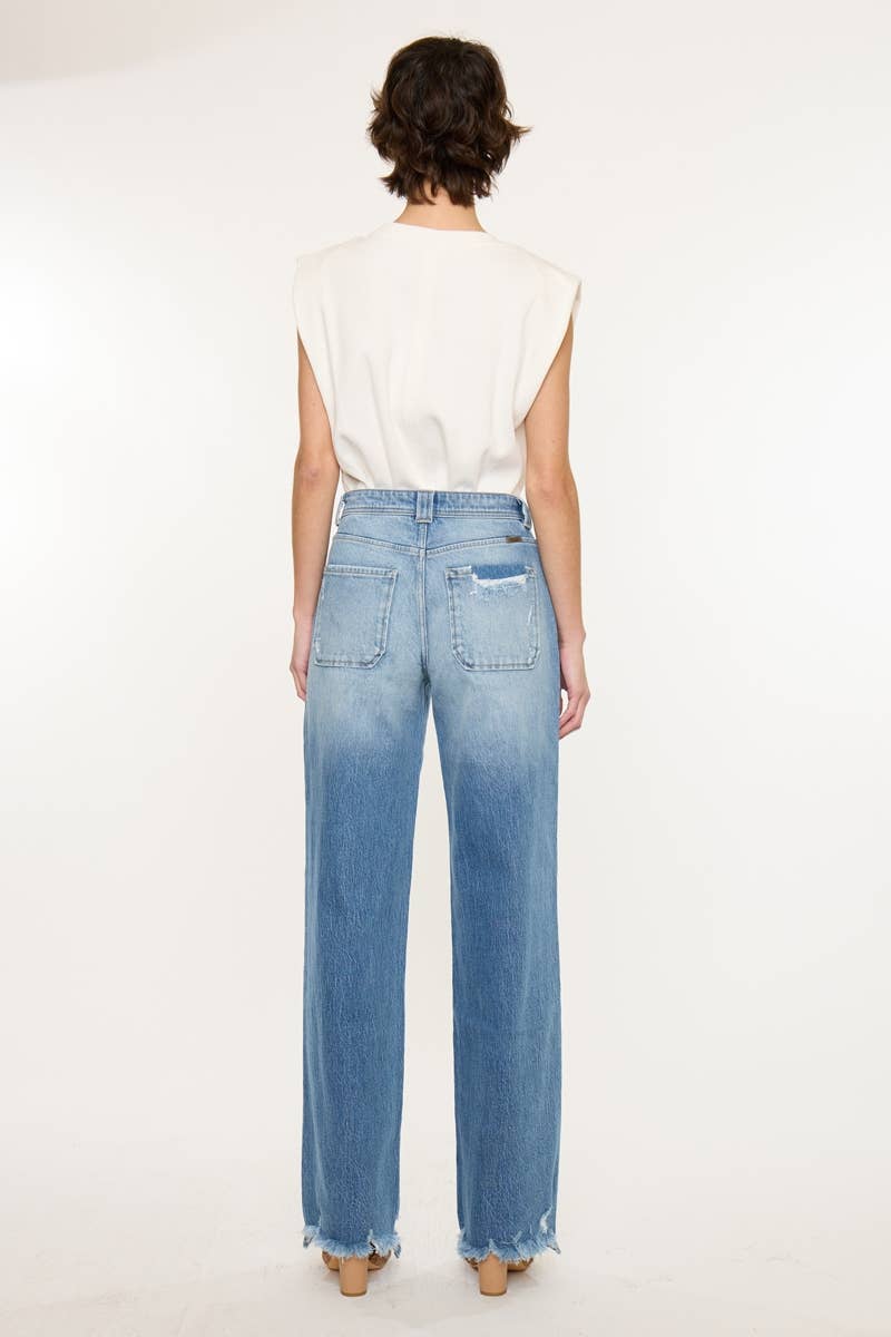 Person wearing light blue jeans and a white top on a white background