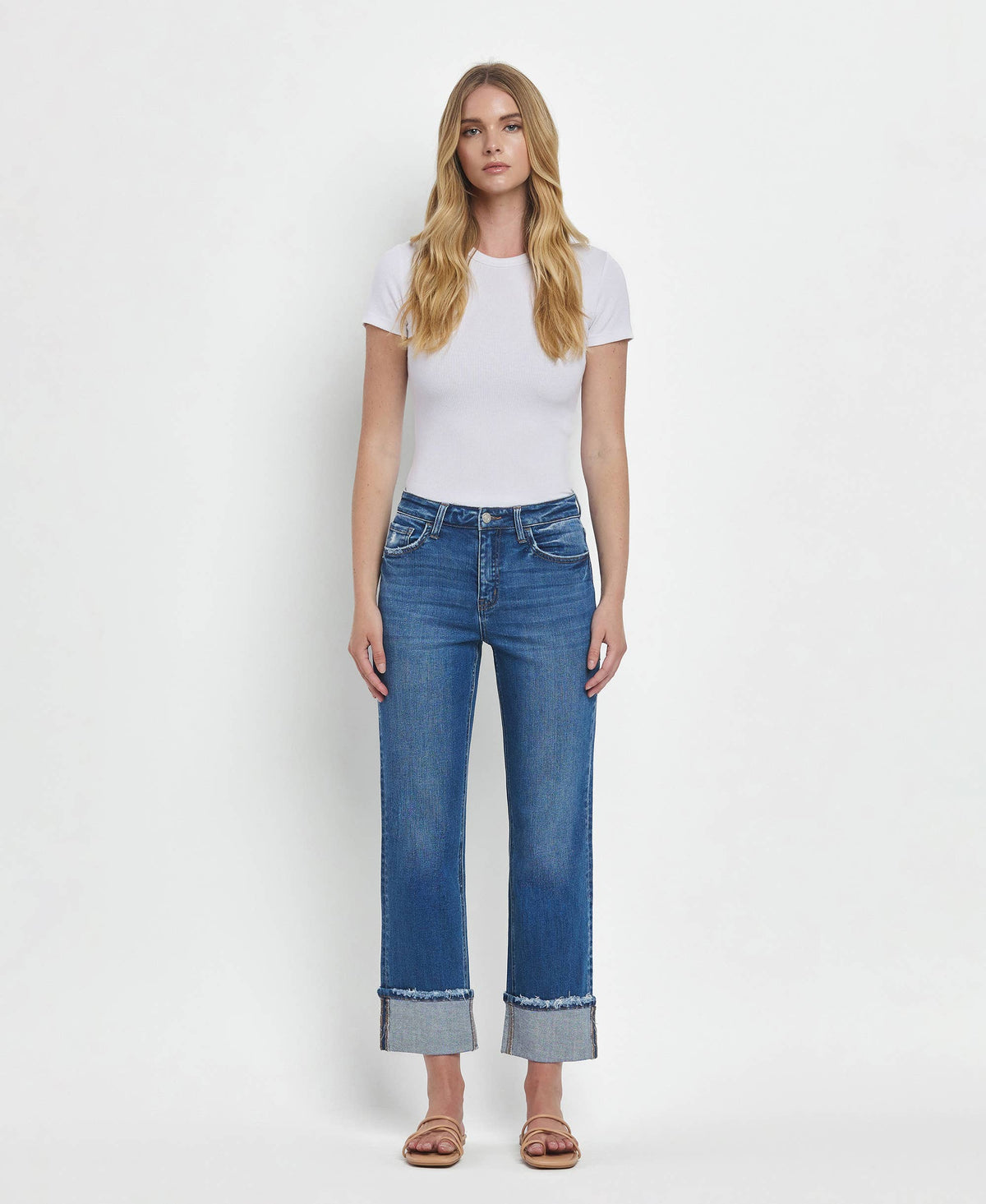 Woman wearing blue jeans and a white t-shirt on a white background