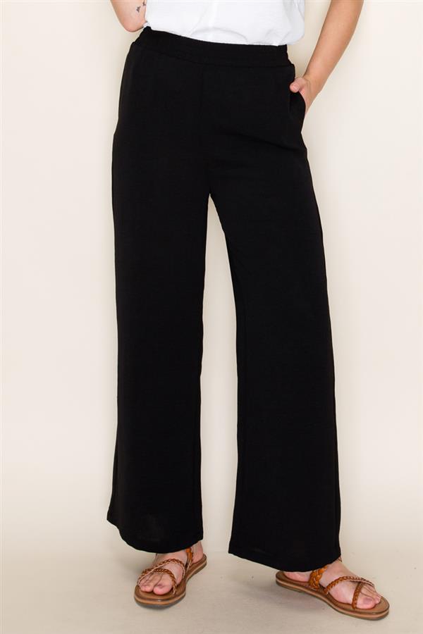 Person wearing black wide-leg pants against a plain background