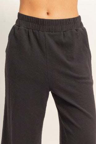 Dark gray sweatpants on a light beige background