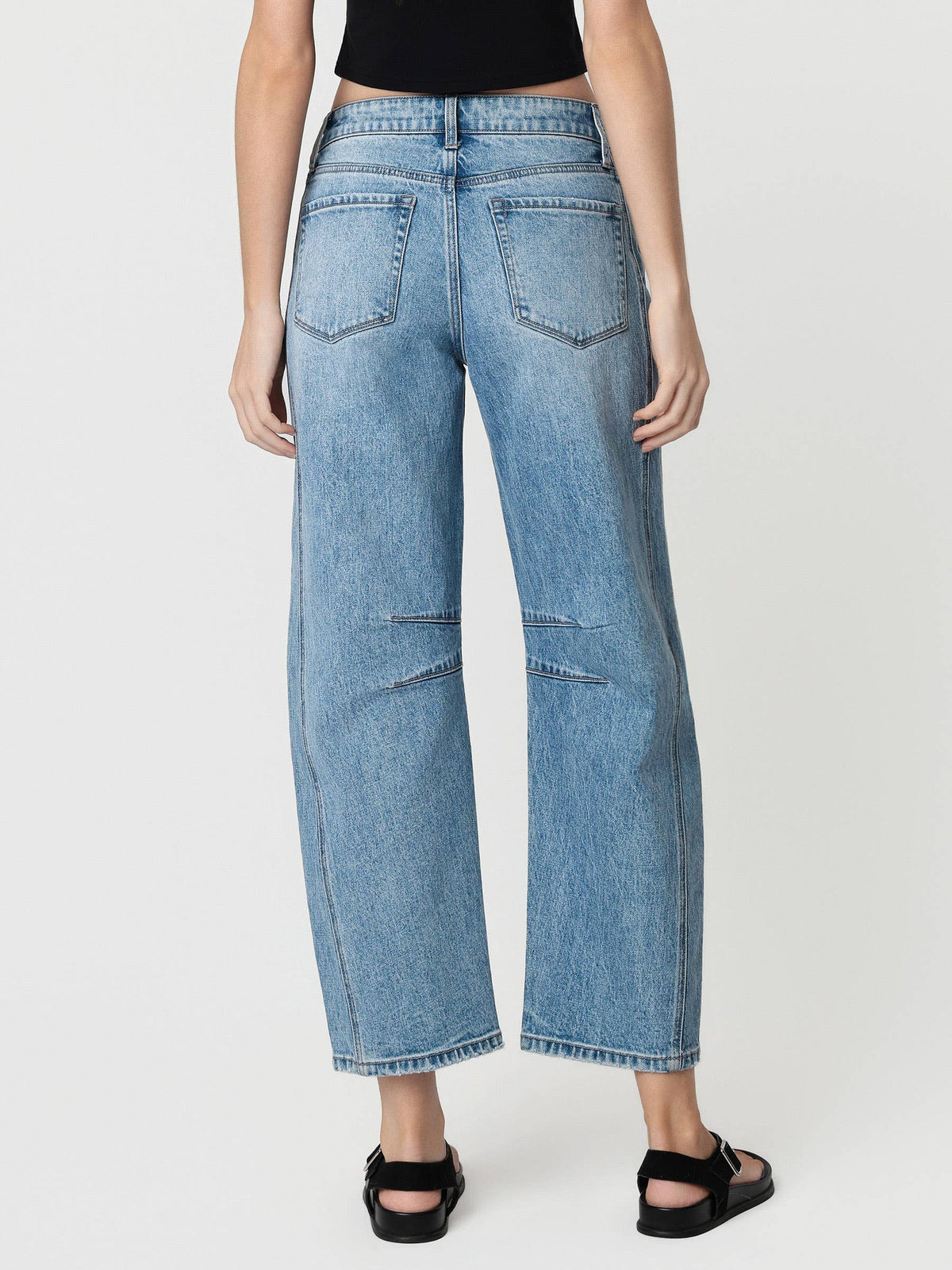 Person wearing light blue jeans on a white background