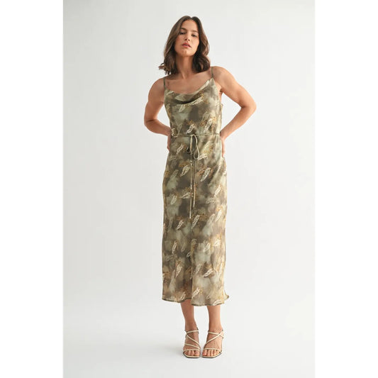 Woman wearing a green and beige patterned dress on a white background