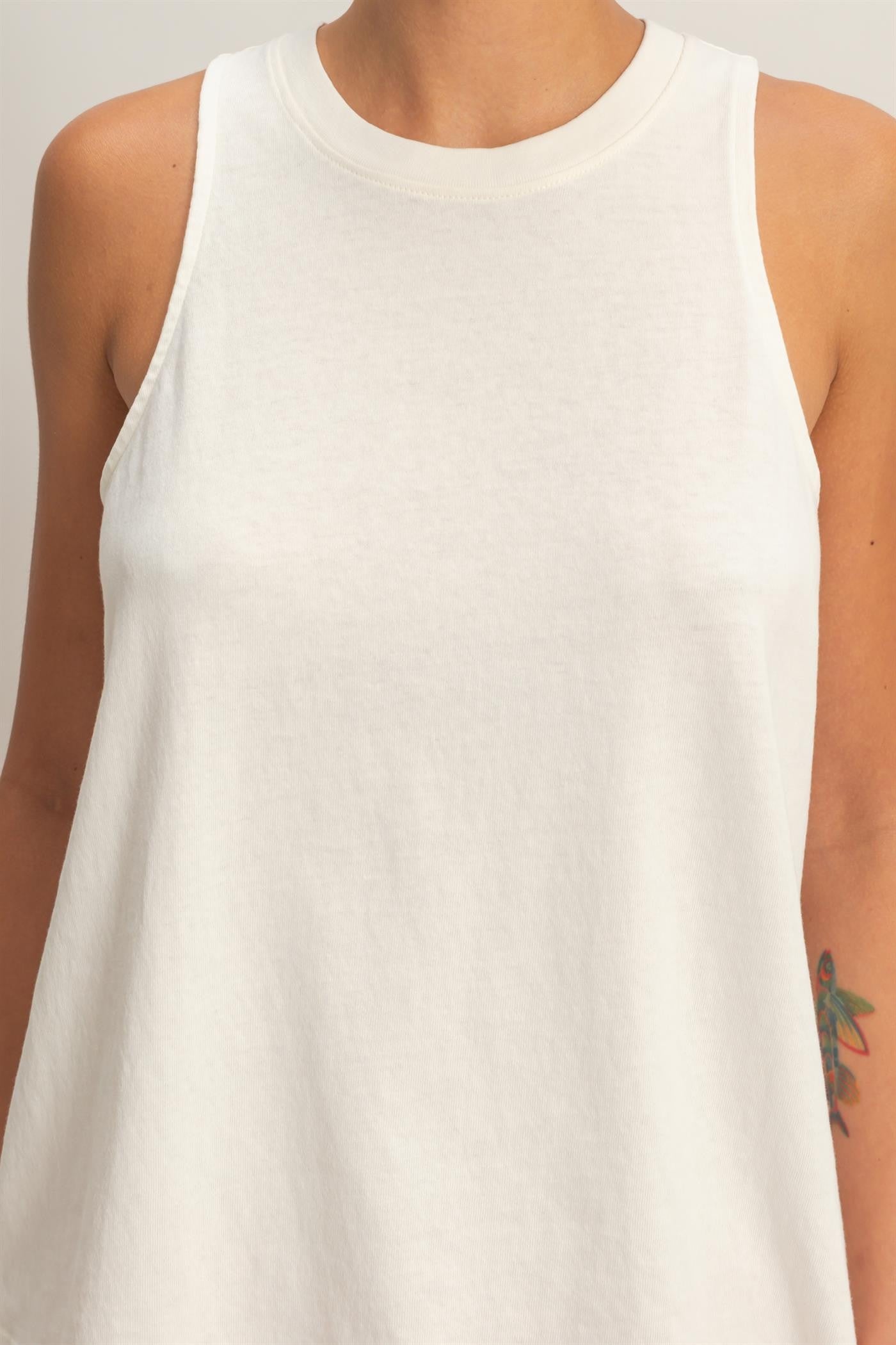 White sleeveless top worn by a person on a plain background