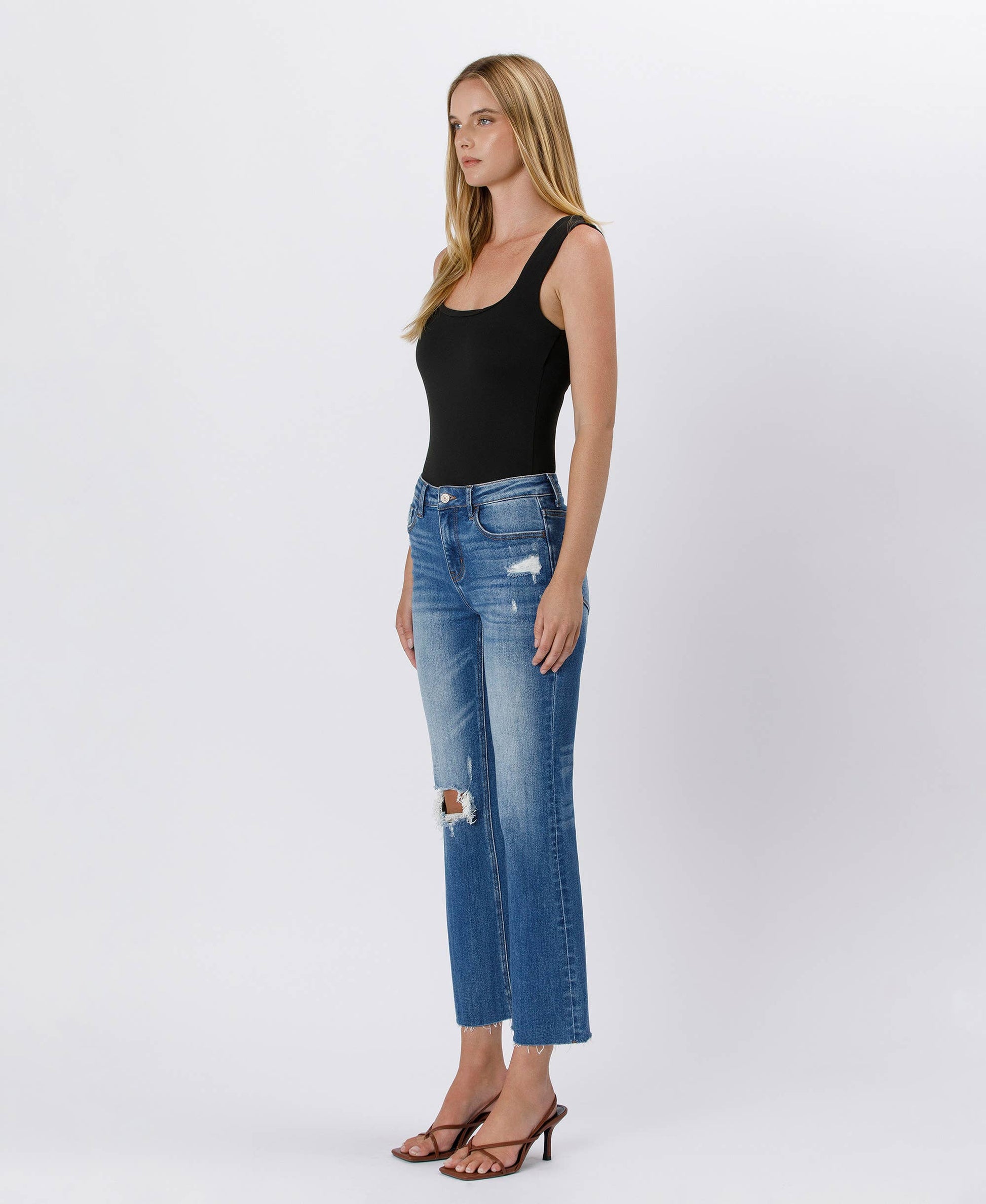 Woman wearing blue jeans with a white background