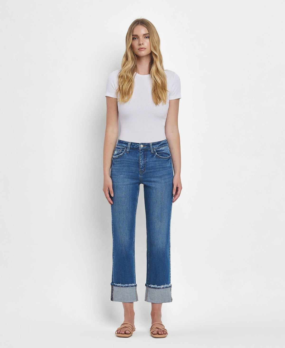 Woman wearing blue jeans and a white t-shirt on a white background