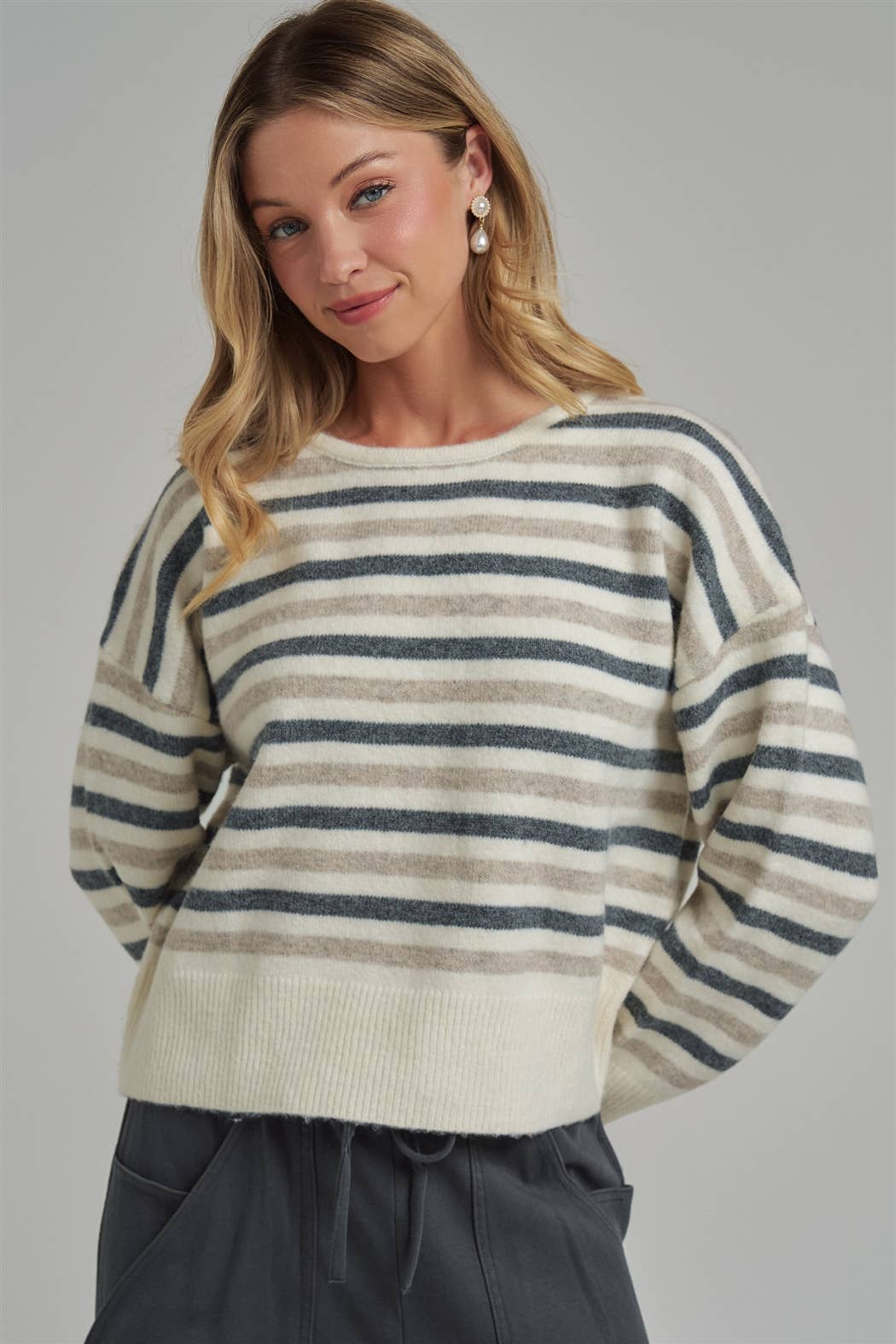 Woman wearing a striped sweater against a plain background