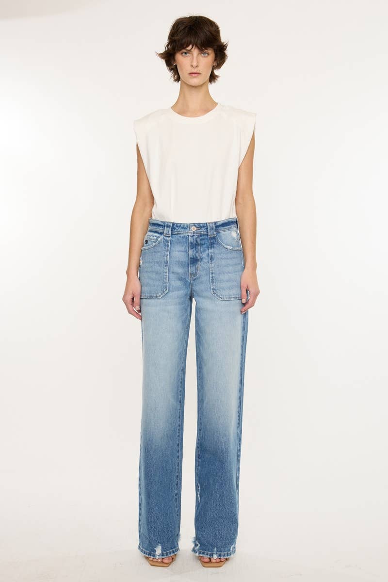 Person wearing a white sleeveless top and light blue jeans on a white background
