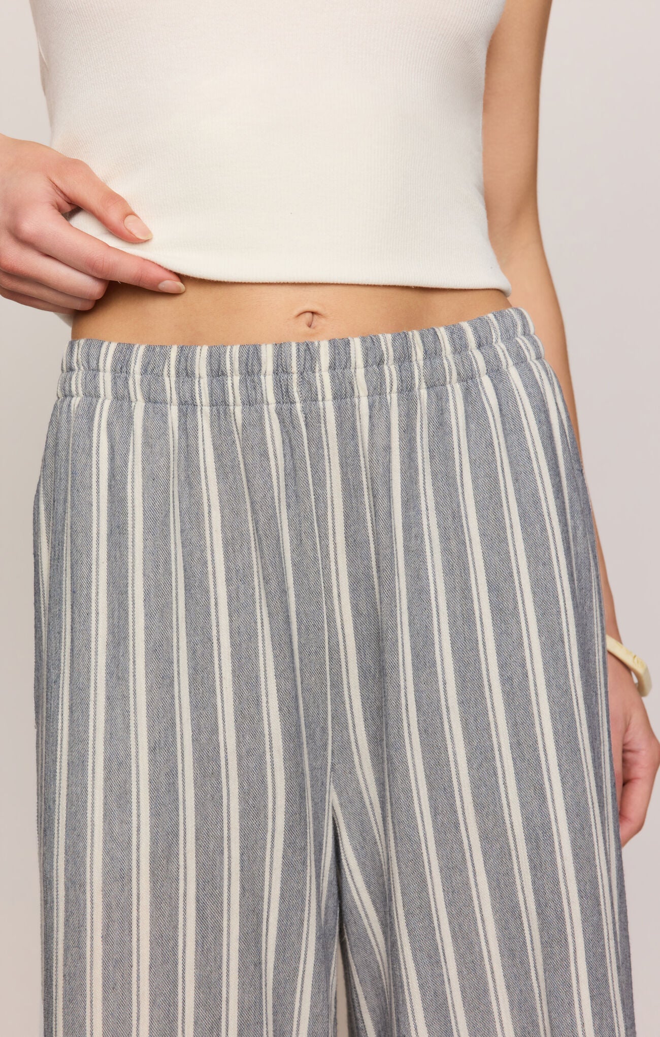 Person wearing blue and white striped pants with a plain background