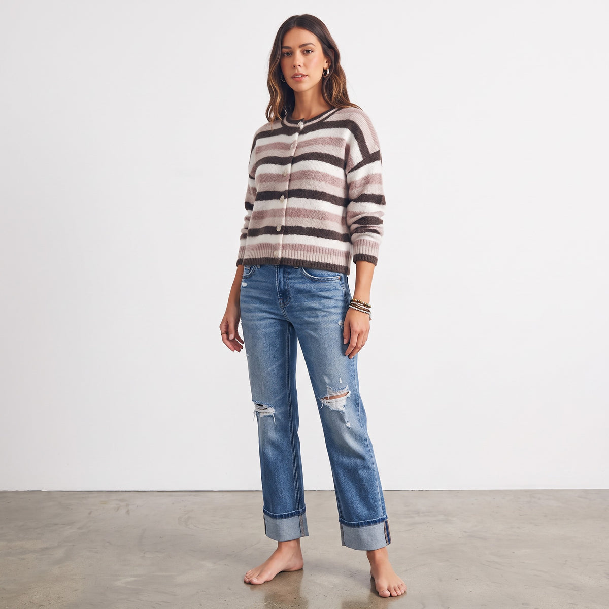 Model wearing Apricot Lane Duluth Sophie soft striped button-front cardigan with blue distressed denim jeans