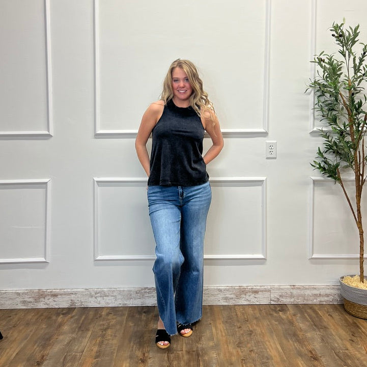 Woman standing in a room with white paneled walls and a plant.