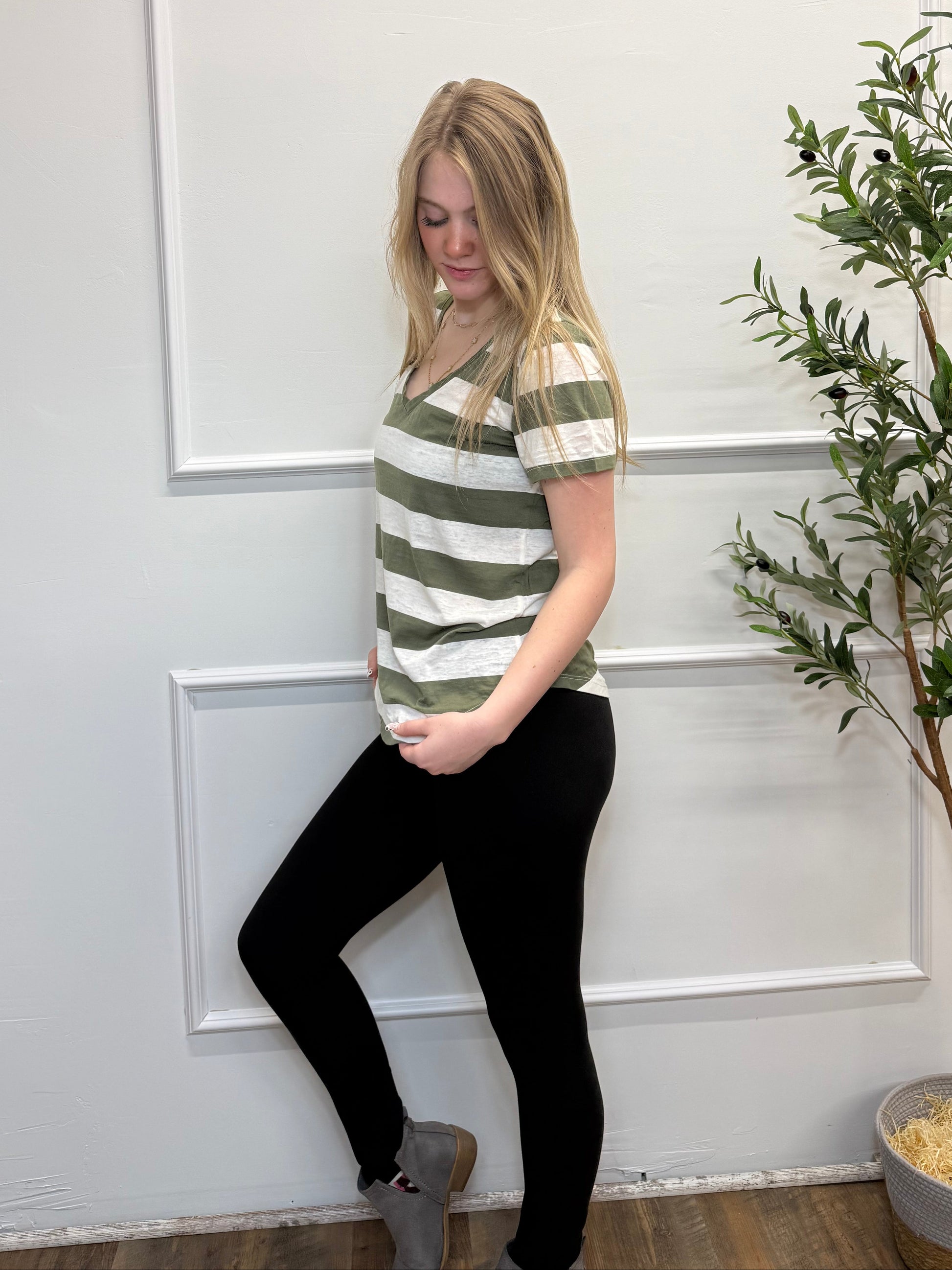 Person lying on a white floor with a plant in the background