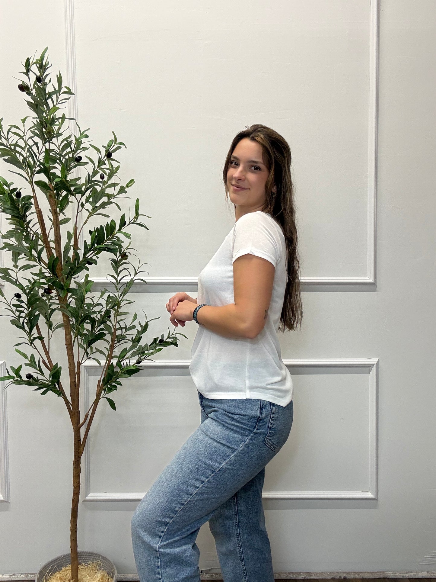 Person lying on a white floor with a plant in the background
