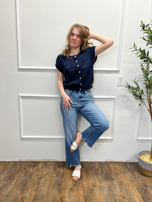 Person wearing a blue denim outfit lying on a wooden floor with white walls.
