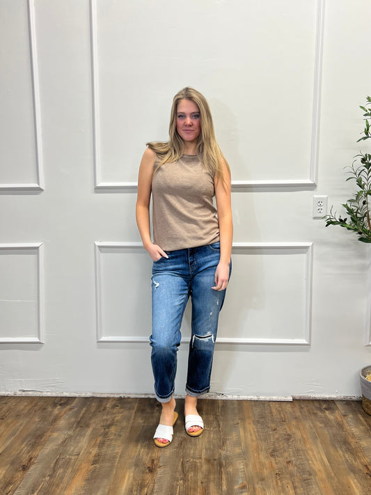 Person standing in a room with a white door and wooden floor.