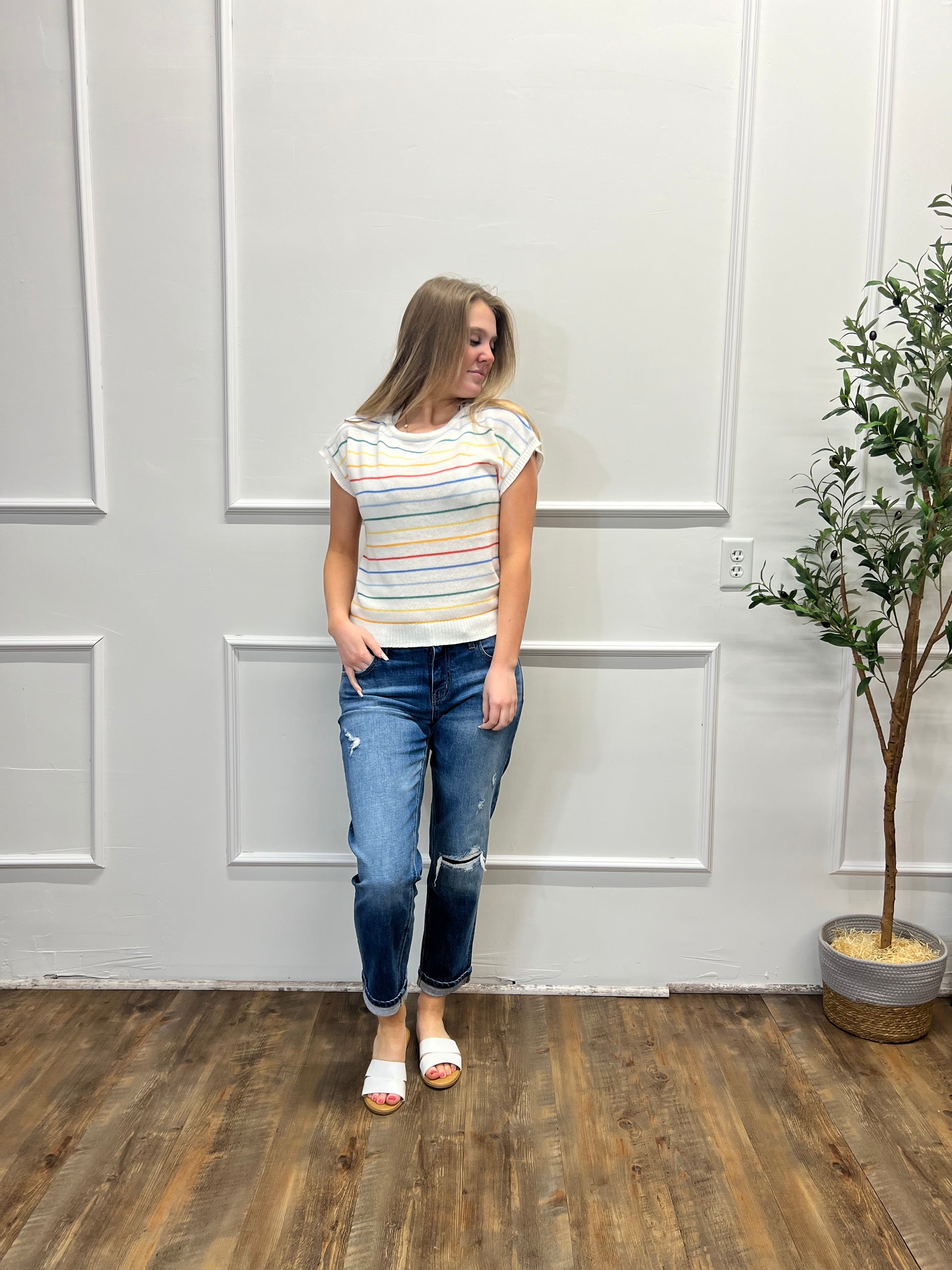 Person standing in a room with a white door and wooden floor.