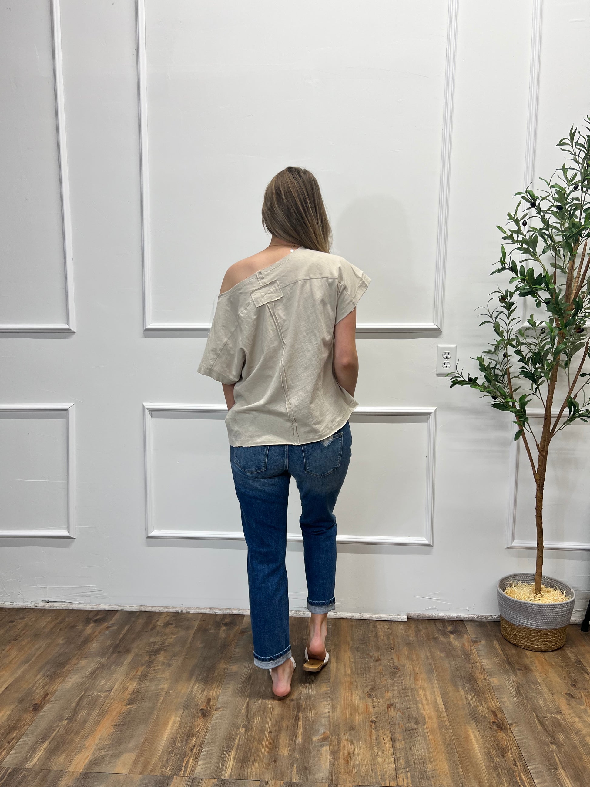 Person standing in a room with a white door and wooden floor.
