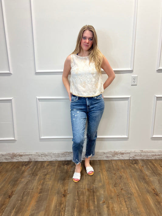 Woman standing in a room with wooden flooring and white walls.