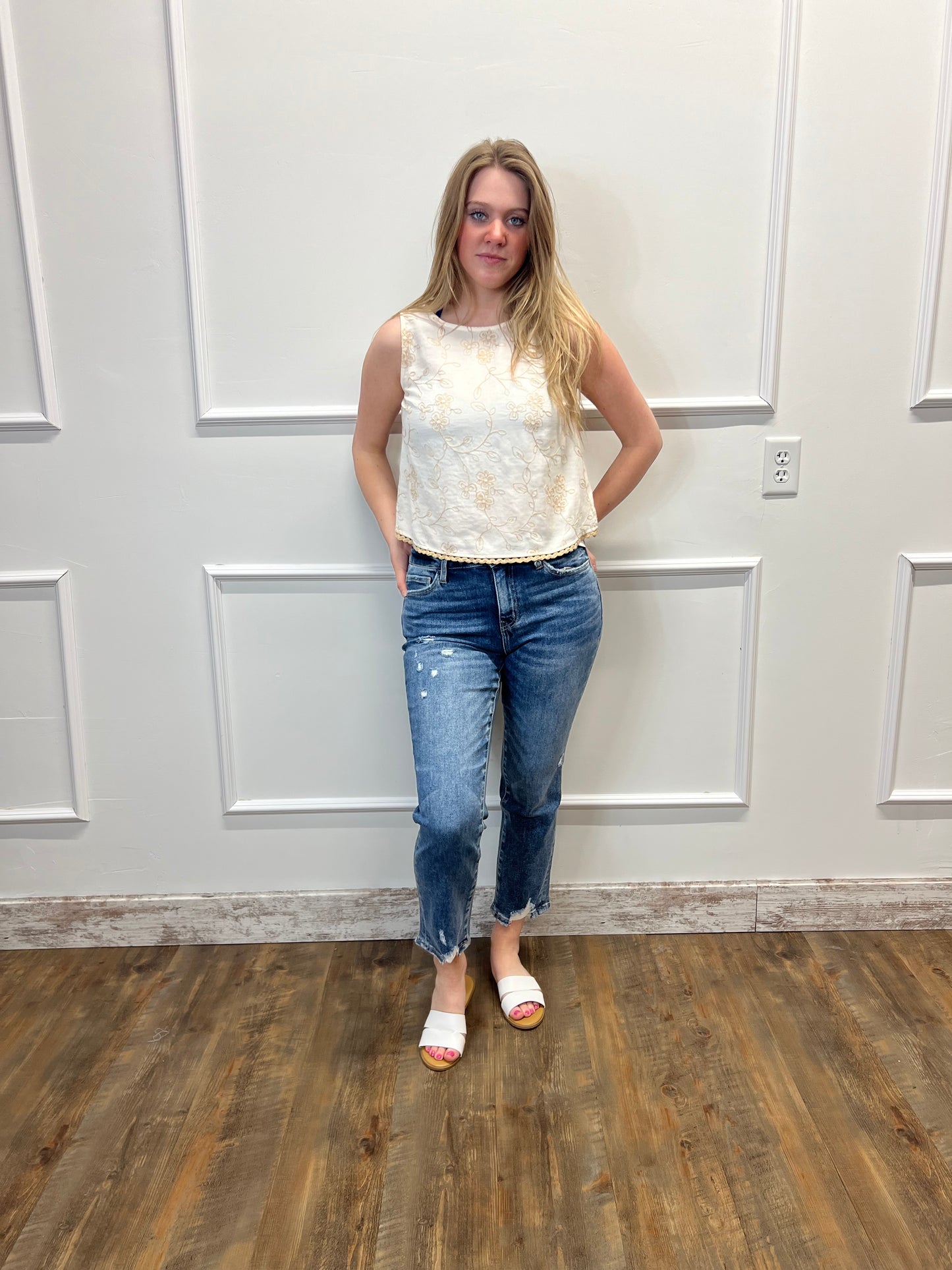 Person standing in a room with wooden floor and white walls