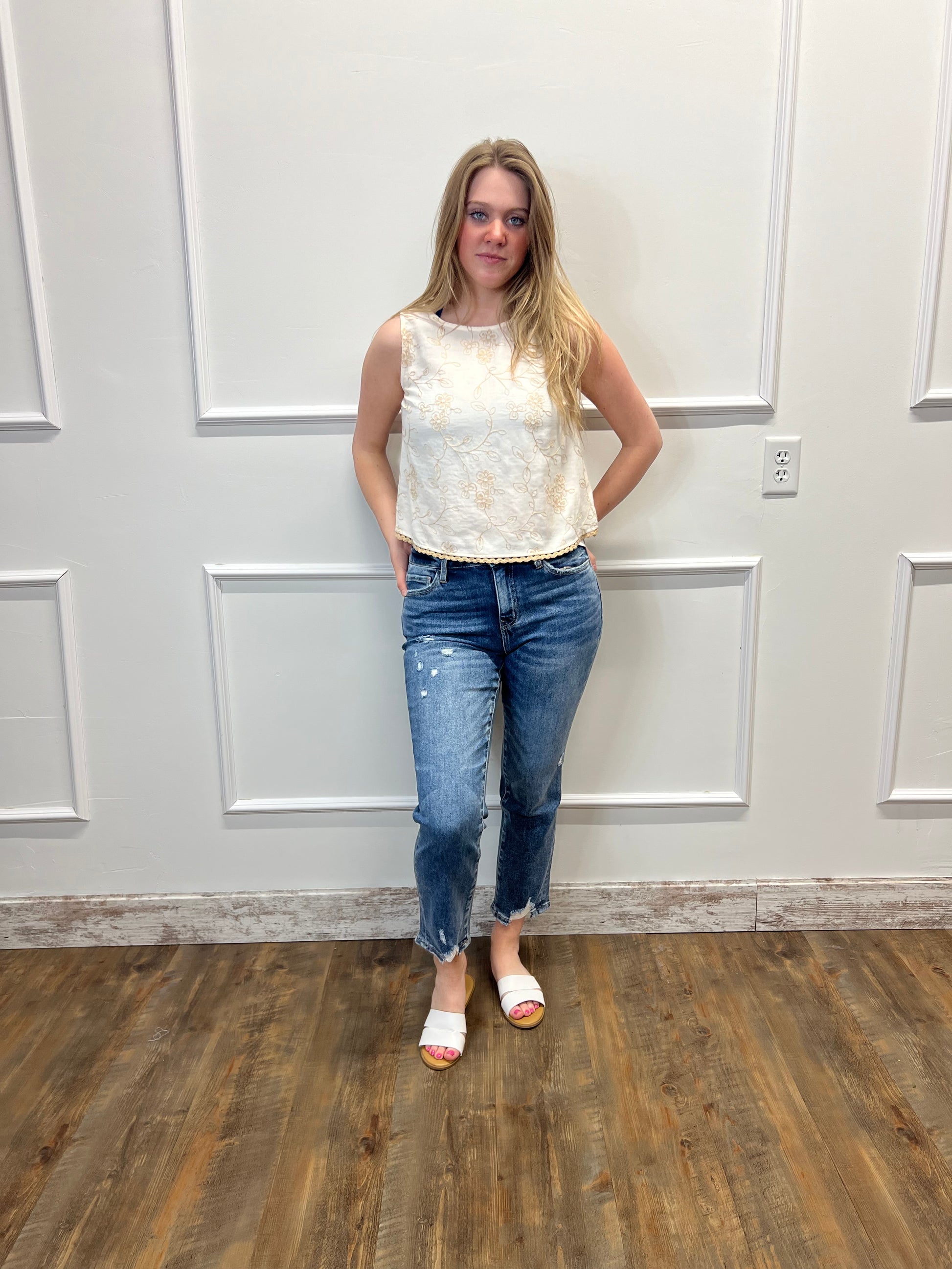 Person standing in a room with wooden floor and white walls