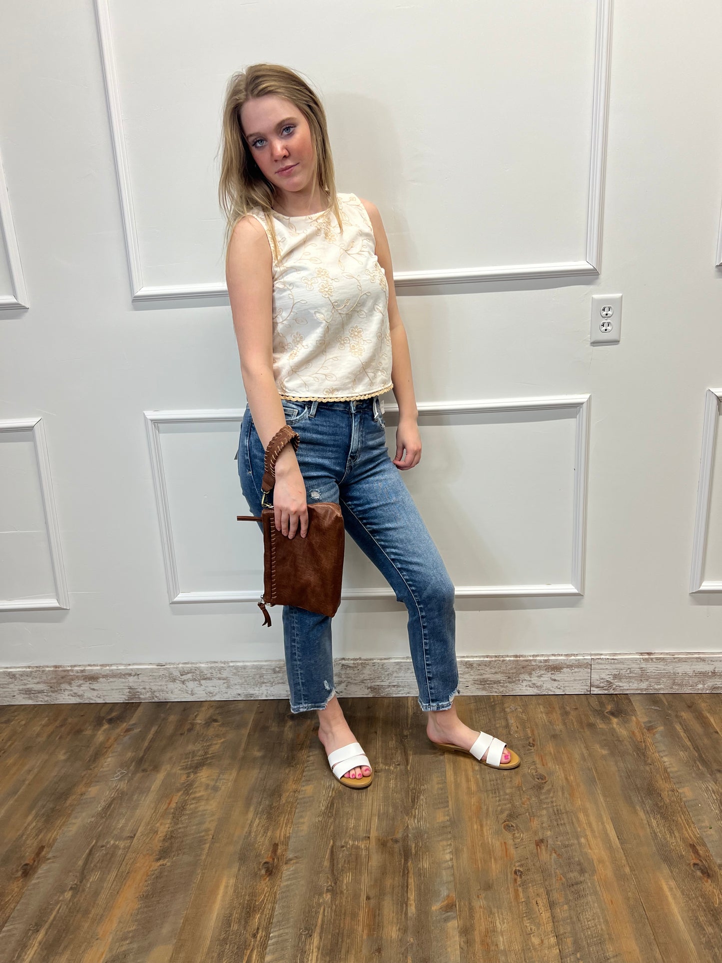 Person standing in a room with a white door and wooden floor.