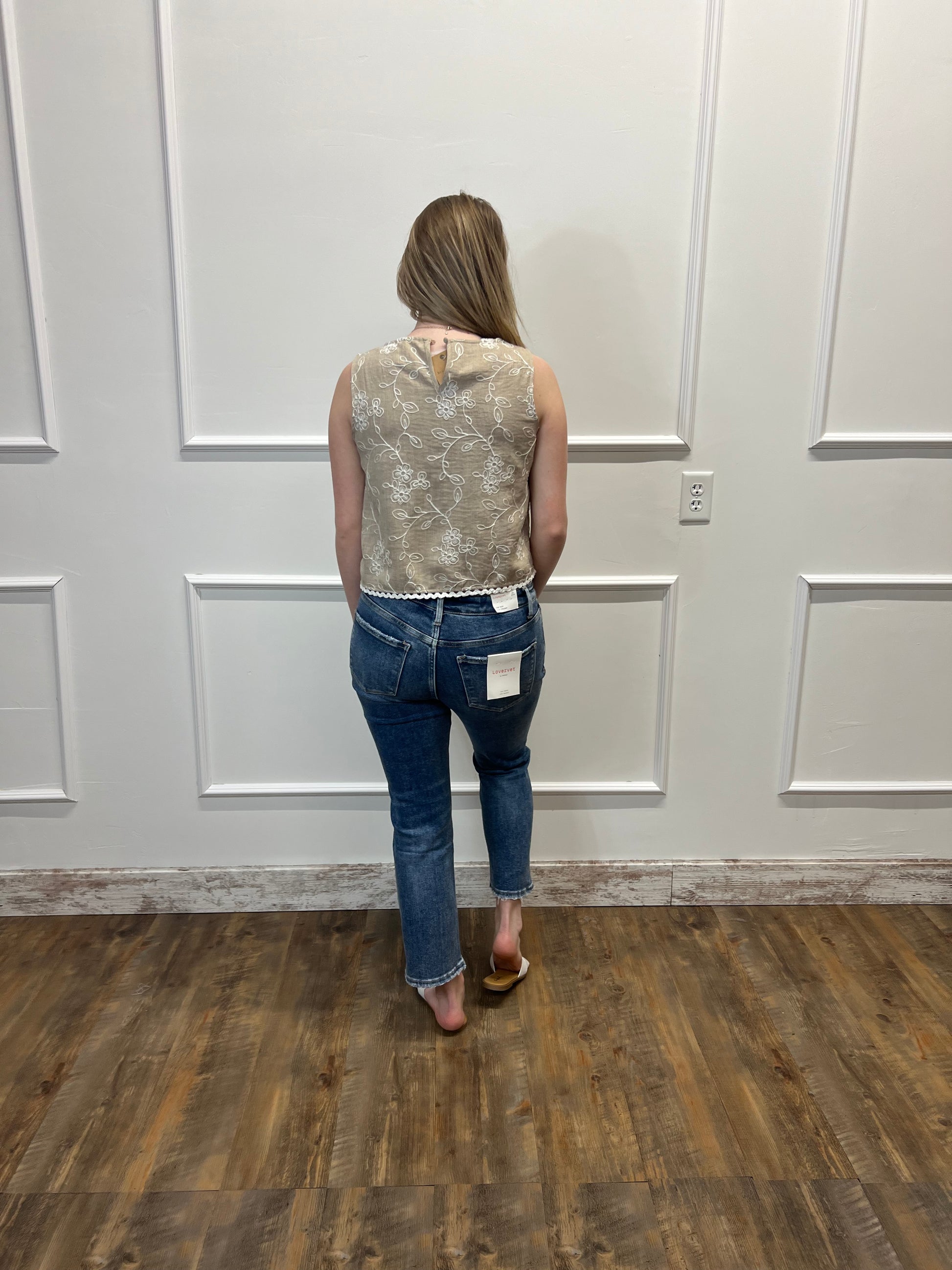 Person holding a textured bag in front of a white door with wooden floor.